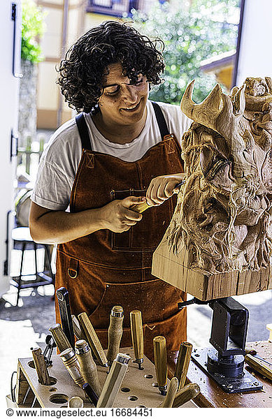 Bildhauerin schnitzt Holzfigur in der Arbeit