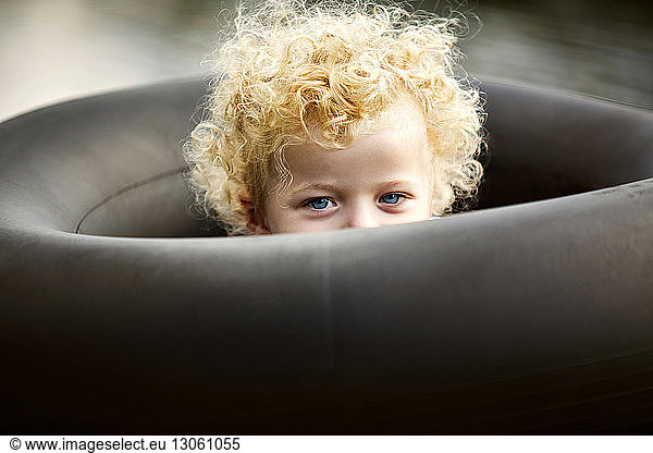 Bildnis eines Jungen inmitten eines schwarzen aufblasbaren Rings