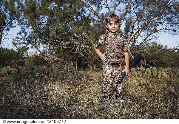 Bildnis eines Mädchens mit Gewehr auf Grasfeld