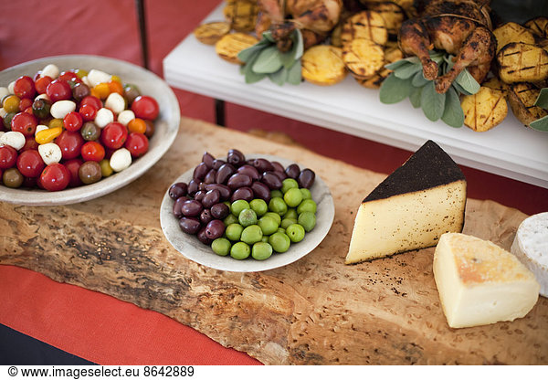 Bio-Lebensmittel auf weißen Gerichten für eine Party. Käse  Freilandhühner  historische Tomaten und Salatzutaten. Lebensmittel vom Bauernhof.