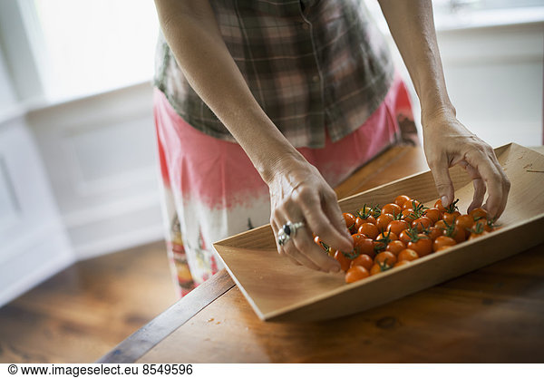 Biologische Erzeugnisse. Ein Tablett mit frisch gepflückten Bio-Tomaten in der Küche.