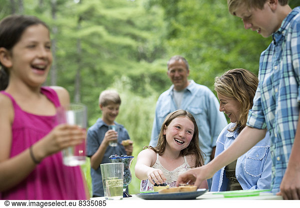 Biologische Landwirtschaft. Eine Familienfeier im Freien mit Picknick. Erwachsene und Kinder.
