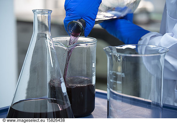 Biotech Scientist pouring purple liquid during a science expierment