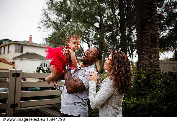 Biracial Couple Holding & Smiling at Baby
