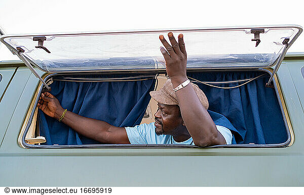 black african american man in the window of his camper van