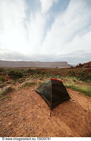 black and orange tent with views of red sandstone buttes in utah