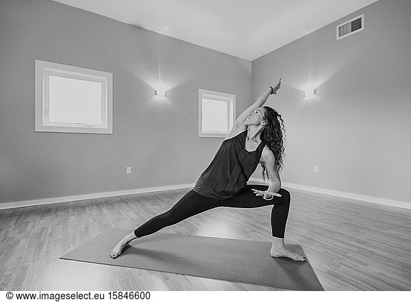 black and white image of middle age woman doing yoga in a studio
