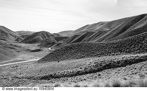 Black and white photo  barren mountain landscape with pass road  Lindis Pass  Southern Alps  Otago  South Island  New Zealand  Oceania