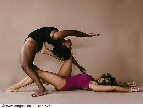 Black female dancers in backbend and leg lift pose together