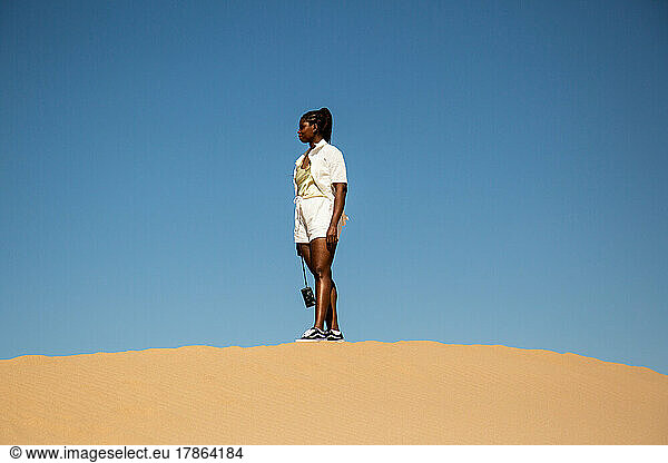 Black girl on sand dune in California
