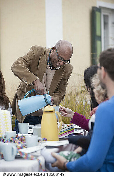 Black man serving coffee at family party  Bavaria  Germany