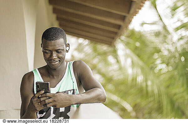 Black man using smartphone on terrace