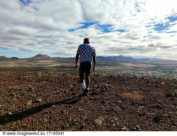 Black man with a red hat on top of volcano in Fuerteventura