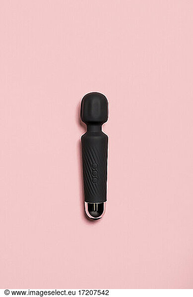 Black sex toy against pink background