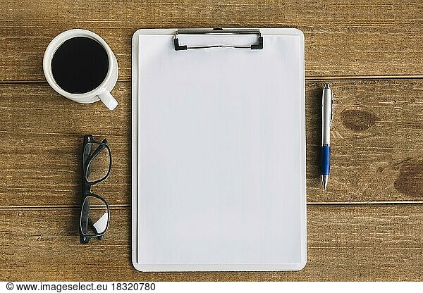 Black tea pen spectacles blank white papers with clipboard wooden background