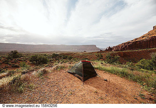 black tent setup near moab utah under red sandstone buttes