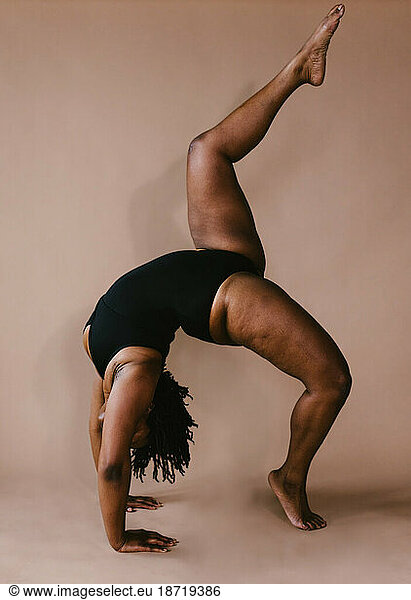 Black woman dancer in backbend with leg lift dance pose