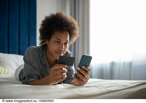 Black woman entering credit card credentials in smartphone