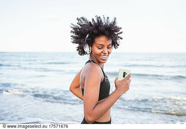 black woman laughing and having fun dancing on the beach