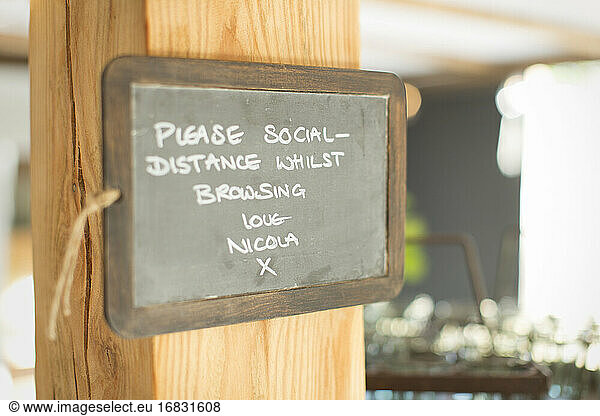 Blackboard social distancing sign in small shop