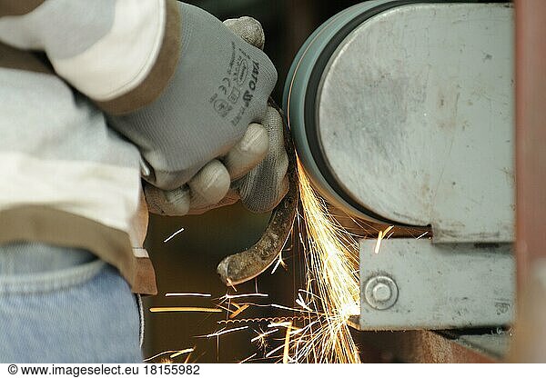 Blacksmith at work  grinding horseshoes