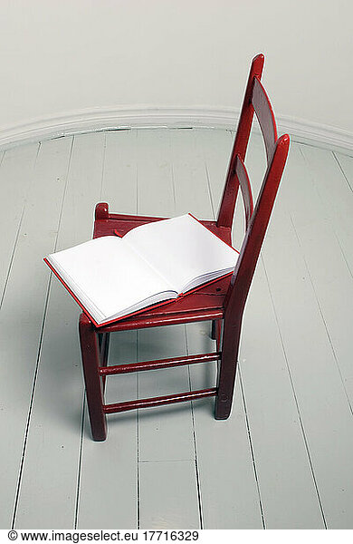 Blank Book On A Red Chair In A While Room