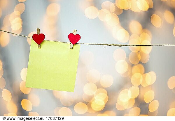 Blank Yellow Haftnotiz hängen mit roten Herzen mit Bokeh Hintergrund  romantische Valentinstag Konzept Hintergrund Kopie Raum Liebe.