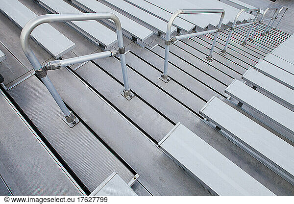 Bleachers  looking down the steep steps and raked seating of a stadium.