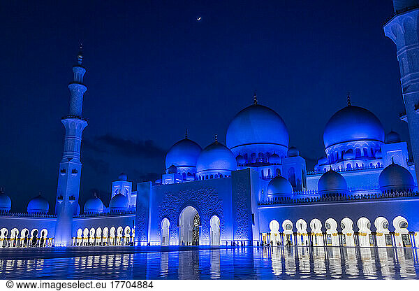 Blick auf den Haupteingang der Großen Moschee in Abu Dhabi  Vereinigte Arabische Emirate  in einer Viertelmondnacht. Die Außenbeleuchtung ist so gestaltet  dass sie die Lichtzyklen des Mondes nachahmt; Abu Dhabi  Vereinigte Arabische Emirate