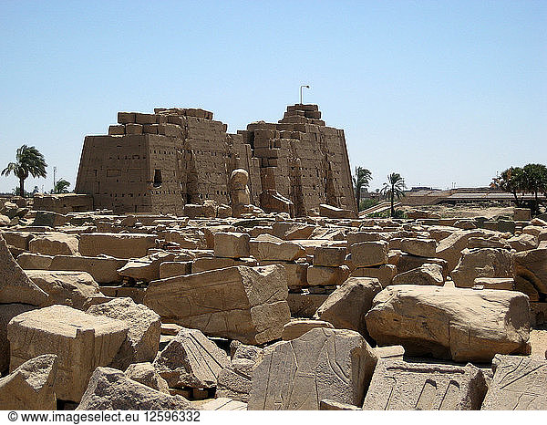 Blick auf den 7. Pylon der von Tuthmosis III. erbaut wurde und vor dem die Überreste zweier sitzender Kolosse des Pharaos zu sehen sind.