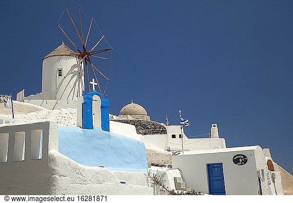 Blick auf eine traditionelle Windmühle und eine orthodoxe Kirche im Dorf Oia  Santorin  Kykladen  Griechische Inseln  Griechenland  Europa.
