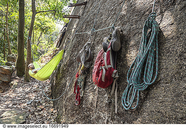 Blick auf einen männlichen Felskletterer  der sich in einer Hängematte im Regenwald ausruht