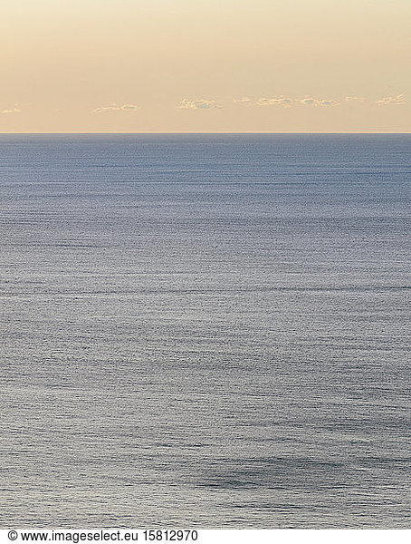 Blick auf ruhiges Ozeanwasser  Horizont und Himmel in der Morgendämmerung
