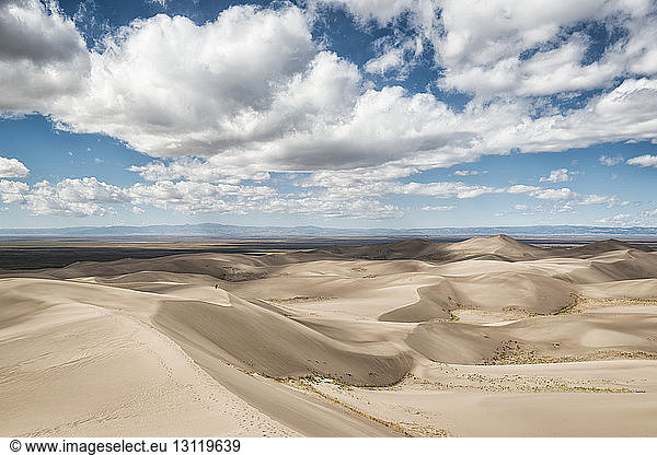 Blick auf Sanddünen vor bewölktem Himmel