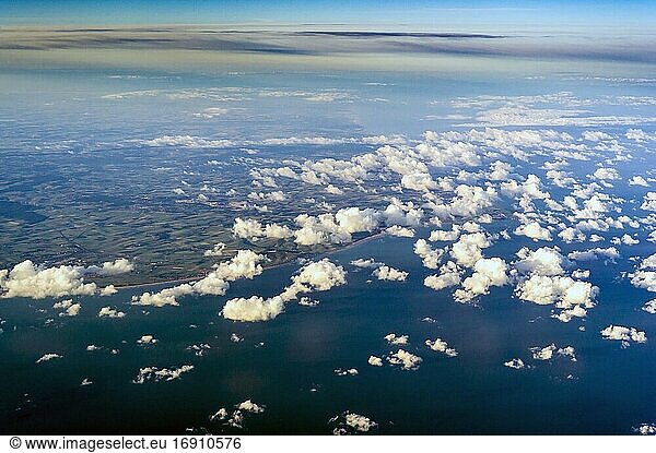 Blick aus dem Flugzeugfenster auf die Wolken und den Himmel über uns.