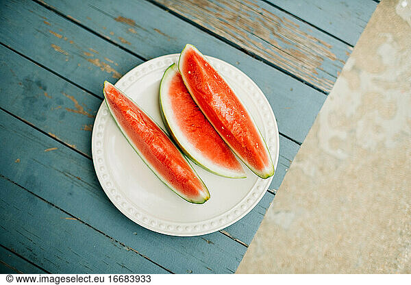 Blick von oben auf drei Scheiben frischer Wassermelone auf der Veranda