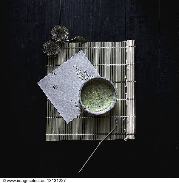 Blick von oben auf Matcha-Tee in Schale auf Platzdeckchen