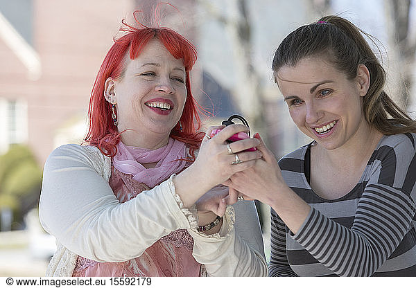 Blind young women using assistive technology on their cell phones