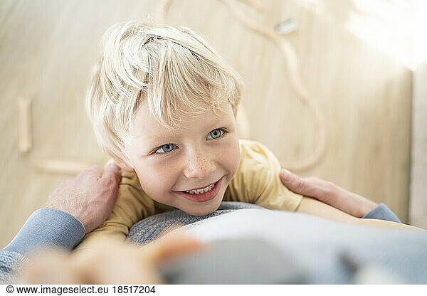 Blond boy having fun with father at home