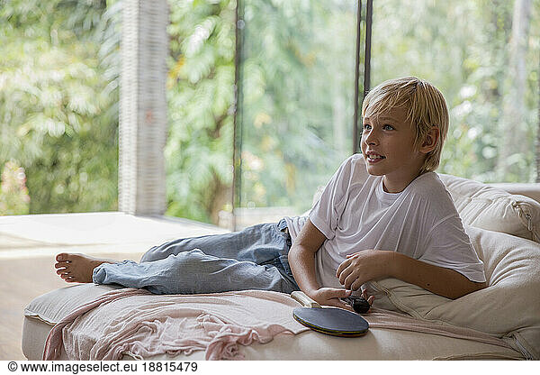 Blond boy watching TV at home
