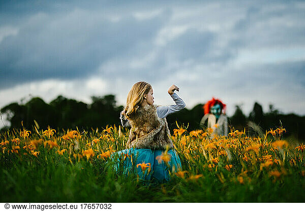 Blond female strong child is brave with monster orange flower field