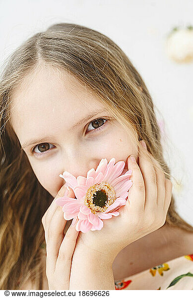 Blond girl holding pink flower
