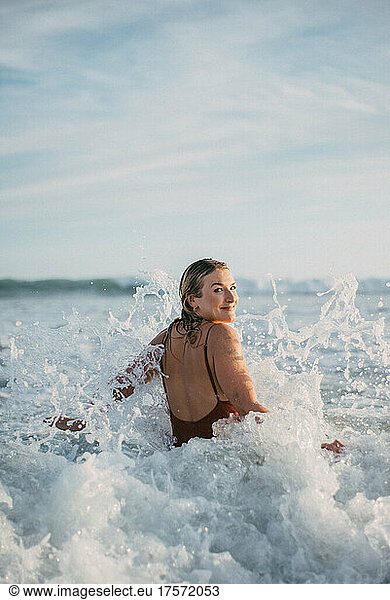 blond girl playing with the waves on the beach