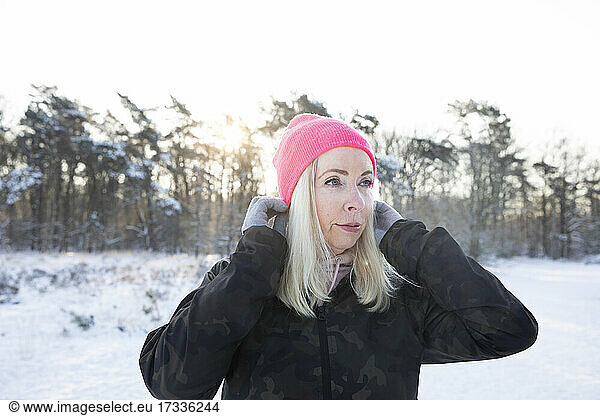 Blond senior woman wearing pink knit hat during winter