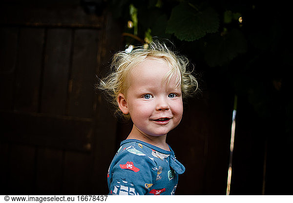 Blond Two Year Old Boy in Pajamas Smiling for Camera