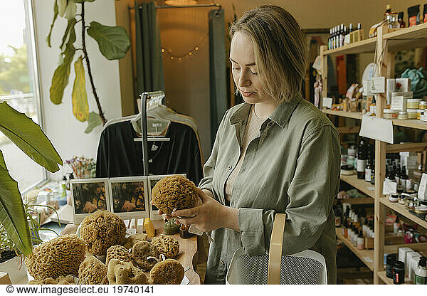 Blond woman choosing organic washcloth and shopping in store