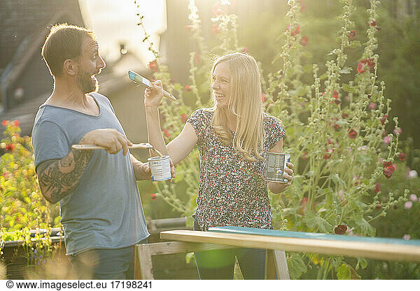 Blond woman doing mischief with boyfriend in garden