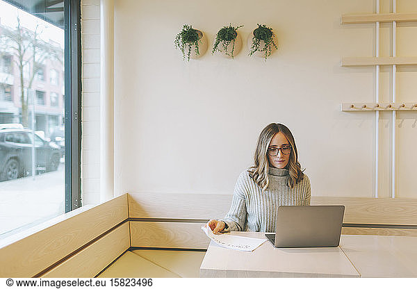 Blond woman using laptop in a cafe