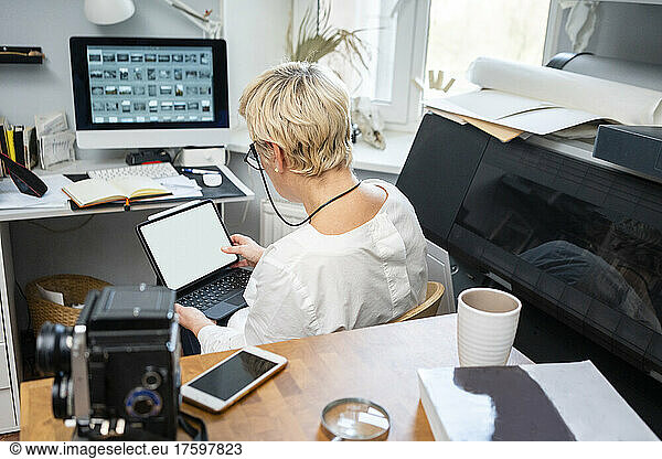 Blond woman using tablet PC in office