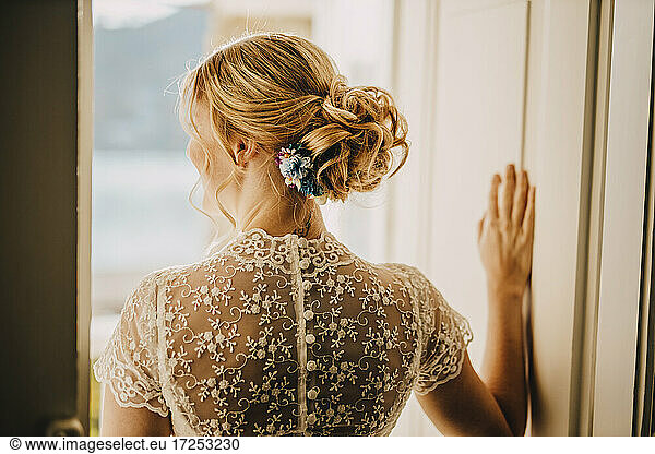 Blonde Braut mit Haarknoten im Hochzeitskleid